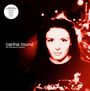 „Carina Round, the first blood mystery“. Eine Frau blickt nach vorne in einer rot getönten, nächtlichen Straßenszene.