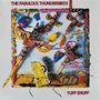 Text: "THE FABULOUS THUNDERBIRDS" oben, "TUFF ENUFF" unten. Bunte Collage mit Totemfiguren und Dekorationen.