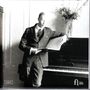 Beschriftungen: "CLASSICAL", "FUGA LIBERA". Ein Mann in Anzug lehnt entspannt an einem Klavier, hält Noten in der Hand.