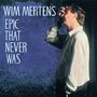 WIM MERTENS EPIC THAT NEVER WAS. Ein Mann im Hemd hält seine Hand ans Gesicht vor einem blauen Hintergrund.