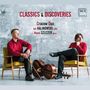 "CLASSICS & DISCOVERIES. Cracow Duo. Jan Kalinowski, Cello. Marek Szlezer, Piano." Zwei Männer in roten Hemden, eine sitzt auf einem Stuhl, der andere lehnt an einem Cello.