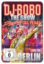 DJ BOBO, The Show, Dancing Las Vegas, LIVE IN BERLIN. Ein lächelnder Mann im goldenen Anzug zeigt auf etwas.