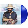 Text: "Bill Withers, Naked & Warm". Ein Mann mit Strohhut und gemustertem Poncho lächelt vor einem blauen Himmel.