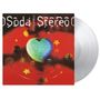 "Soda Stereo Dynamo" in weißer Schrift auf rotem Hintergrund, ein leuchtendes Herz und umkreisende Kugeln. Vinyl daneben.