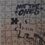 Texte "NOT THE ONES" oben und "B-Side" auf Puzzlestück. Hand hält Puzzleteil, das in Puzzle einzufügen ist.