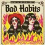 Text: "HANA & JESSIE-LEE'S Bad Habits SAY WHAT YOU MEAN". Zwei Frauen umgeben von Flammen, retro künstlerischer Stil.