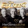 "Die Edlseer" Schrift oben, "Herzenssache" unten. Drei Männer vor Alpenkulisse.