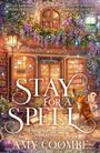 "Stay for a Spell", ein gemütlicher Buchladen. Katzenfigur auf Büchern. Weinreben, buntes Licht und Magieatmosphäre.