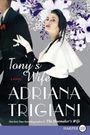 „Tony's Wife“ von Adriana Trigiani. Frau mit blauem Schal und weißen Handschuhen vor blumigem Hintergrund.