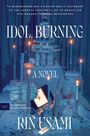 Text: "A NOVEL, Idol Burning, RIN USAMI, TRANSLATED BY ASA YONEDA." Der Hintergrund zeigt Kerzen und Bücherstapel in Blau.