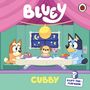 Text: "Bluey", "Cubby", "A Lift-the-Flap Book". Zwei Hunde sitzen an einem Tisch in einem Zelt.