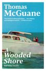 Titel: "A Wooded Shore". Autor: Thomas McGuane. Rezension von The Wall Street Journal. Boot auf blauem Wasser.