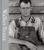 Text "Walker Evans". Ein Mann in Latzhose lehnt an einer Holzwand, blickt ernst nach vorn. Vintage Fotografie.