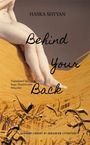 Oben steht "Haska Shyyan", darunter "Behind Your Back". Ein Bein ist über ein anderes geschlagen, umgeben von Stroh.