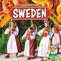 "Life and Traditions in Sweden". Drei Frauen und ein Kind in traditionellen Trachten spielen Geige.