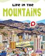 "Life in the Mountains", "Janine Deschenes". Hochhäuser vor Berglandschaft, Logo unten rechts.