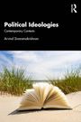 "Political Ideologies", "Contemporary Contexts", Arvind Sivaramakrishnan. Ein geöffnetes Buch liegt im Gras vor einem Strand.