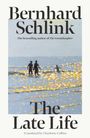 Bernhard Schlink: The Late Life. Silhouetten von zwei Personen am Strand, umgeben von goldenen Lichtern.