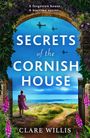 Buchtitel: "Secrets of the Cornish House". Eine Frau in lila Kleid blickt auf Küstenlandschaft mit Flugzeugen im Himmel.