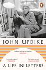 „John Updike: A Life in Letters“. Zitate von The Times, Telegraph, Financial Times. Ein Mann sitzt in einem Sessel.