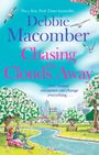 „No.1 New York Times bestseller. Debbie Macomber. Chasing the Clouds Away. One chance encounter can change everything...“  
Darunter eine farbenfrohe Illustration eines Pärchens im Park am Fluss. Im Hintergrund sind blühende Bäume und eine Stadt.