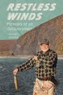 „RESTLESS WINDS: Memoirs of an Outdoorsman“ von Donald C. Jackson. Ein Angler hält einen Fisch am Fluss vor einer Hügelkulisse.