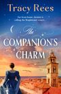 Text: "Tracy Rees. Far from home, destiny is calling the Brightwater sisters... The Companion’s Charm." 

Eine Frau in blauem Kleid schaut auf eine Küstenstadt bei Sonnenuntergang.
