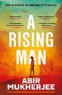 "A Rising Man" von Abir Mukherjee. Silhouette eines Mannes in Kolonialuniform vor einem gelb-orangefarbenen Hintergrund.