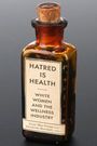 Auf einem braunen Glasgefäß steht: "HATRED IS HEALTH. WHITE WOMEN AND THE WELLNESS INDUSTRY. Anna Mae Duane und Elizabeth Marshall, editors."