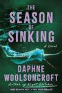 „THE SEASON OF SINKING“ steht in lila Text. Eine Person treibt unter Wasser in einem Kleid.