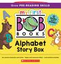 "my first BOB Books Alphabet Story Box" steht auf einer gelben Box mit fröhlichen Tierillustrationen und Buchstaben.