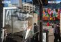 ALEX WEBB, WALKING BLUES: Reflexion einer Person in Schaufenster, Hintergrund mit buntem Wandbild, Straßenszene.