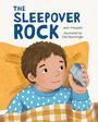 „THE SLEEPOVER ROCK“ steht groß darüber. Ein Junge im blauen Pullover hält einen Stein, lächelnd im Bett.