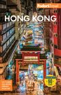 Text: "Fodor's Travel", "HONG KONG". Darstellung: Eine belebte, beleuchtete Straße mit Marktständen und traditionellem Torbogen.