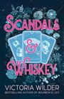 "Scandals & Whiskey" in großen pinken Buchstaben, darunter "Victoria Wilder". Blaue Blumen, drei Spielkarten.