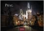 Prag 2027. Casares Edition. Eine nächtliche Stadtansicht mit beleuchteten Türmen und historischer Architektur.