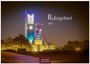 "Ruhrgebiet 2027." Ein beleuchteter industrieller Turm, umgeben von Bäumen und einem ruhigen, dunklen Himmel.