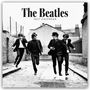 "The Beatles 2027 Calendar" steht oben. Vier Männer in Anzügen springen fröhlich in einer Backsteingasse.