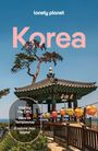 Texte: "lonely planet," "Korea," "Visiting the DMZ," "How to Templestay," "Explore Jeju Island." Traditionelles Pavillon, bunte Laternen.
