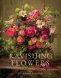 "Ravishing Flowers" mit üppigem Blumenarrangement in kräftigen Farben, darunter Lilien und Rosen, auf rustikalem Tisch.
