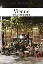 "Vienne: L’autre Guide" oben, "Éditions Jonglez" unten. Nachtaufnahme eines lebhaften Straßencafés, Bäume im Hintergrund.