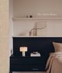 "The Quiet Home" in ruhiger, minimalistischer Schlafzimmerdekoration: Bett, Nachttisch, Lampe und dekorative Objekte.