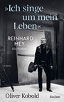 "Ich singe um mein Leben." Reinhard Mey, ein Porträt. Oliver Kobold. Schwarz-weiß Foto eines Mannes mit Gitarre.