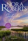 „Nora Roberts, Suche des Herzens“ oben, „Zwei Romane in einem Band“ auf einem lila Kreis. Malerische Landschaft mit Wasser und Gräsern.