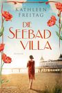 "KATHLEEN FREITAG DIE SEEBAD VILLA ROMAN" steht vor rotem Mohn. Frau im roten Kleid am Strand geht auf ein Gebäude zu.