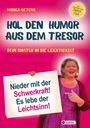 "Hol den Humor aus dem Tresor. Nieder mit der Schwerkraft! Es lebe der Leichtsinn!" Frau hält Schild.