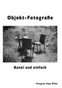 "Objekt-Fotografie. Banal und einfach. Fotograf: Hajo Wilke." Ein Tisch mit drei Stühlen im Gras.