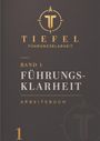 „TIEFEL FÜHRUNGSKLARHEIT, BAND 1, FÜHRUNGSKLARHEIT, ARBEITSBUCH“. Grauer Hintergrund, goldenes Logo mit T.