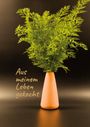 "Aus meinem Leben gekocht" steht neben einer Vase mit frischen grünen Blättern vor dunklem Hintergrund.