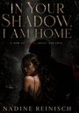 „IN YOUR SHADOW, I AM HOME“ steht groß. Davor eine Frau in Umarmung mit einem Mann, dunkle und mystische Stimmung.